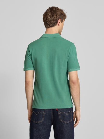 Männermodel trägt Regular Fit Poloshirt aus reiner Baumwolle Modell 'OSCAR' von Pepe Jeans, grün, Optik: Unifarben, Ganzkörperansicht Rückansicht.