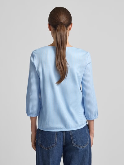 Frauenmodel trägt Regular Fit T-Shirt aus Baumwoll-Mix von Tom Tailor in Hellblau mit feinen Streifen, elastische Abschlüsse, Ganzkörperansicht Rückansicht.