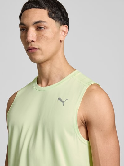 Mężczyznamodel nosi Top mit Logo und Rundhalsausschnitt von PUMA PERFORMANCE w kolorze jasnozielonym, krój regular fit, logo, okrągły dekolt, długość tyłu w rozmiarze M 71 cm, zbliżenie na górną część tułowia.