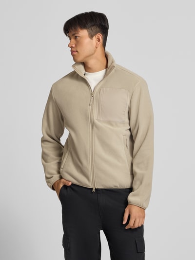 Männermodel trägt Fleecejacke mit Zweiwege-Reißverschluss Modell 'MASON' von JACK & JONES in Beige, Regular Fit, Stehkragen, Logo, Ganzkörperansicht von vorne.