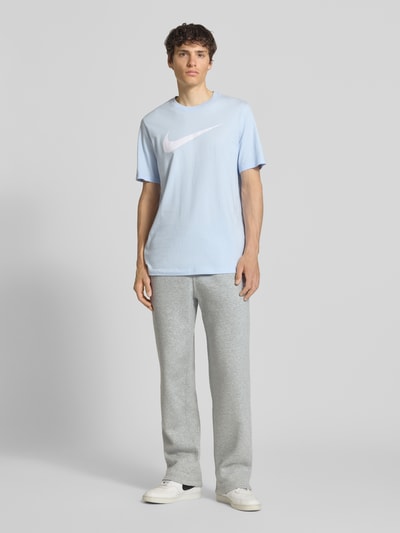 Männermodel trägt Sweatpants mit Logo-Stitching und Eingrifftaschen von Nike aus Baumwoll-Mix, hellgrau, Loose-Fit, Ganzkörperansicht von vorne.