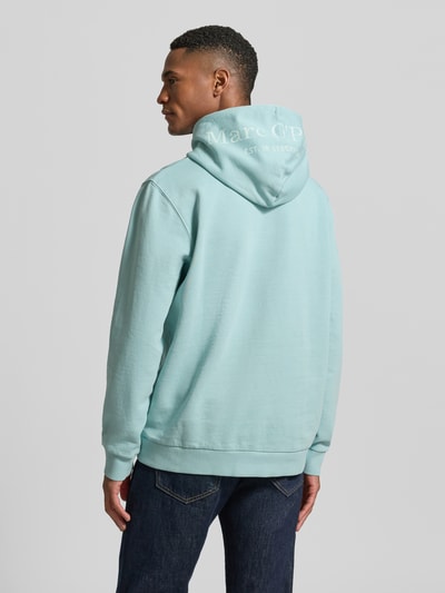 Männermodel trägt Regular Fit Hoodie aus reiner Baumwolle von Marc O’Polo in Hellblau, unifarben, Kapuze mit Label-Schriftzug, Ganzkörperansicht Rückansicht