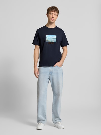 Mannenmodel draagt T-shirt met ronde hals model 'JORNORREBRO' van Jack & Jones, puur katoen, recht model, ruglengte maat M 65 cm, full-body voorkant.