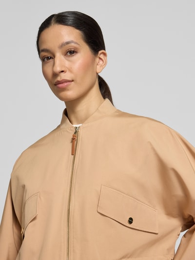 Frauenmodel trägt Jacke mit Zweiwege-Reißverschluss von Rich & Royal aus Baumwoll-Mix in Beige mit Pattentaschen, Nahaufnahme Oberkörper.