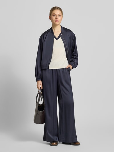 Frauenmodel trägt Blouson mit Stehkragen und Reißverschluss von comma aus Material-Mix mit Viskose-Anteil, dunkelblau, Ganzkörperansicht von vorne.