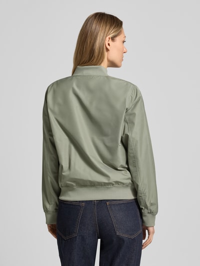 Vrouwenmodel draagt Regular Fit Jacke mit Stehkragen Modell 'Zaymi' van CARS JEANS in groen met steekzakken en ritssluiting, elastische boorden, modelinformatie: ruglengte maat S 61 cm, schouderbreedte 41 cm, borstwijdte 39 cm, mouwlengte 60 cm. Ganzkörperaanzicht achteraan.