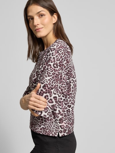 Vrouwenmodel draagt Relaxed Fit T-Shirt uit viscosemix met allover animalprint van Marc Cain, elastisch, ronde hals, halve mouw, zijaanzicht bovenlichaam.