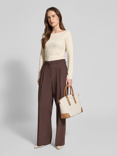 Kobieta nosi torebkę z logo-aplikacją model 'Murphy' od MICHAEL Michael Kors, jasnobrązowy nadruk, widok całej sylwetki z przodu. Szerokość w rozmiarze 1: 40 cm, długość: 26 cm, głębokość: 12 cm, długość paska na ramię: 120 cm.