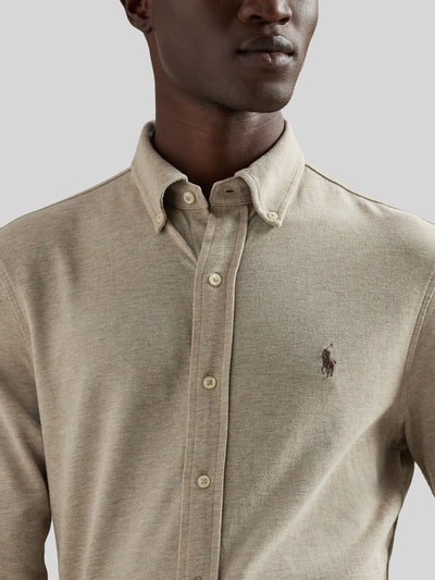 Mannenmodel draagt Regular Fit vrijetijdsoverhemd uit puur katoen van Polo Ralph Lauren, look: effen, bovenstuk, knoopsluiting, button-downkraag, lange mouw, sportmanchet, piqué, logostitching, nahaufnahme bovenlichaam.