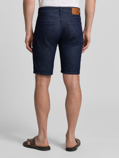 Männermodel trägt Regular Fit Jeansshorts mit Eingrifftaschen Modell 'Sisteron' von Pierre Cardin, dunkles Blau, Baumwoll-Elasthan, Ganzkörperansicht Rückansicht. Herren Jeansshorts, Bundweite 40 cm, Innenbeinlänge 27 cm.
