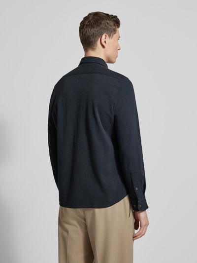 Männermodel trägt Shaped Fit Freizeithemd aus reiner Baumwolle von Marc O'Polo, unifarben, Cutaway-Kragen, Piqué-Struktur, Ganzkörperansicht Rückansicht.