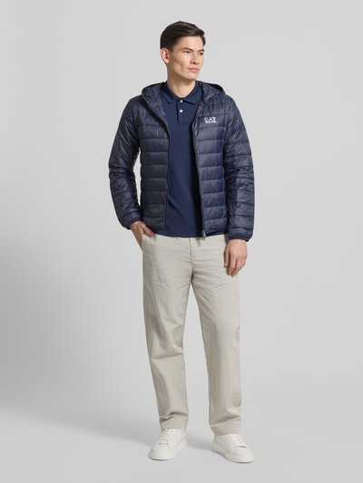 Männermodel draagt Regular Fit Poloshirt met logo van EA7 Emporio Armani, donkerblauw, strakke textuur, mix met stretch, geheelvooraanzicht.