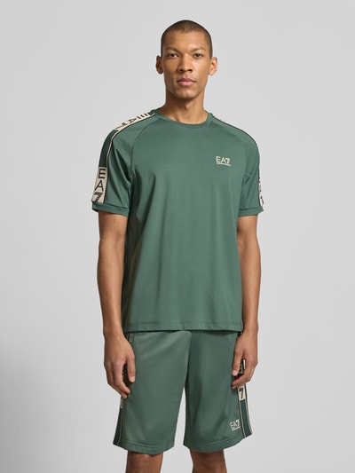 Männermodel trägt T-Shirt aus Viskose-Mix mit Logo von EA7 Emporio Armani, Regular-Fit, Rundhalsausschnitt, Herren, Ganzkörperansicht von vorne.