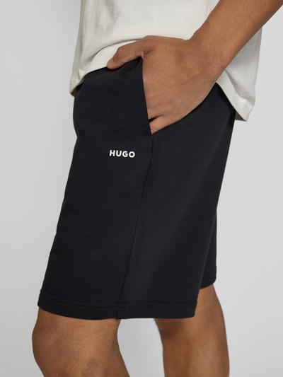 Männermodel trägt Regular Fit Sweatshorts aus reiner Baumwolle Modell 'DAYONO' von HUGO, unifarben, Label Print, Nahaufnahme Oberschenkel.