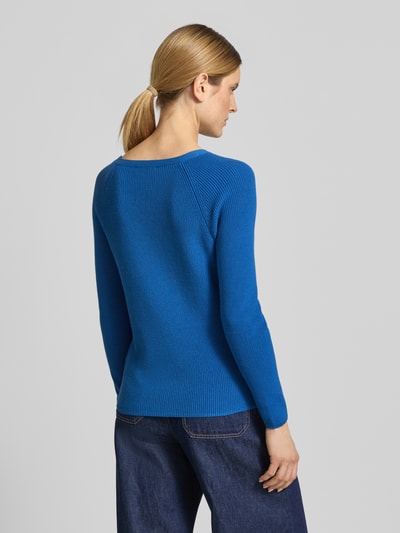 Vrouwenmodel draagt Regular Fit gebreide pullover uit puur katoen van Tommy Hilfiger in felblauw met tricotlook en lange mouw, rompzoom en mouwboord geribd, logo-opschrift, ronde hals, knitwearmateriaal, geheel achteraanzicht.