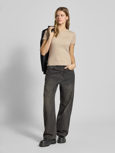 Frauenmodel trägt Slim Fit T-Shirt mit Logo-Stitching von G-Star Raw in Beige, elastischer Baumwoll-Mix, Rib-Optik, Ganzkörperansicht von vorne.