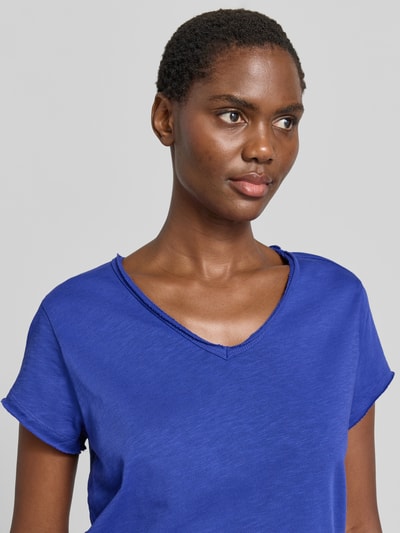 Frauenmodel trägt T-Shirt mit Rollsaum und V-Ausschnitt von Smith and Soul in leuchtendem Blau, reine Baumwolle, Nahaufnahme Oberkörper.