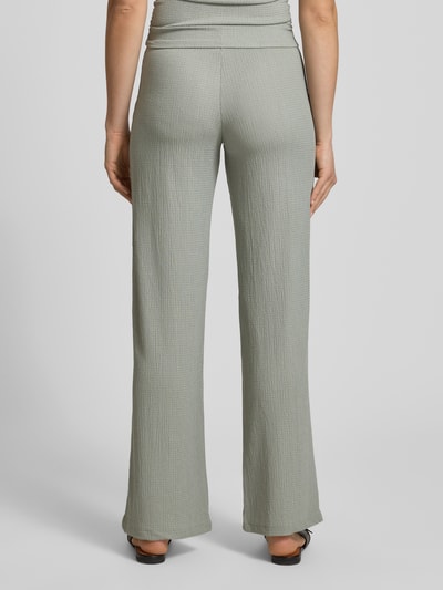 Frauenmodel trägt strukturierte Pull-on-Hose von REVIEW in hellem Grau mit weitem Bein, Stretch-Anteil und elastischem Bund, Ganzkörperansicht Rückansicht.