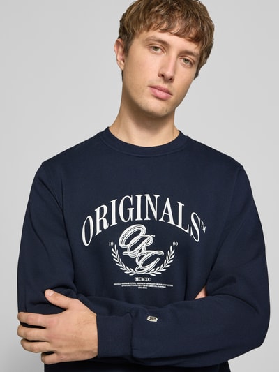 Männermodel trägt dunkelblaues Sweatshirt mit Label-Print Modell 'FREDERIKSBERG' von JACK & JONES, Baumwoll-Mix, Nahaufnahme Oberkörper.