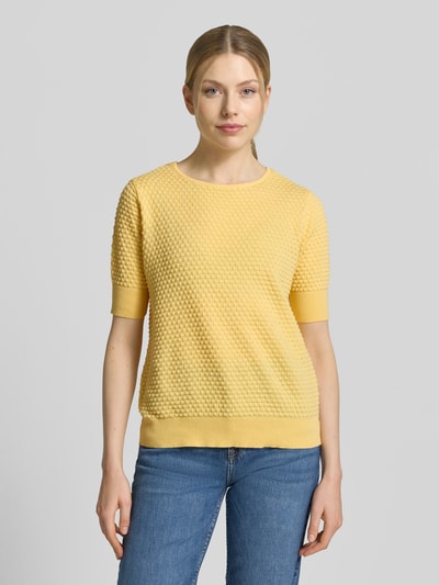 Frauenmodel trägt Strickpullover mit 1/2-Arm Modell 'Dodo' von FREE/QUENT aus reiner Baumwolle in Gelb mit Strukturmuster, Ganzkörperansicht von vorne.