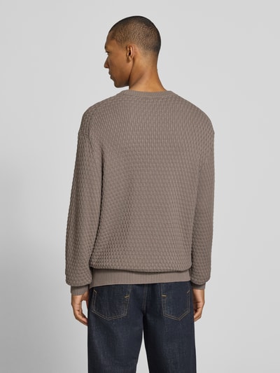 Männermodel trägt Regular Fit Pullover aus reiner Baumwolle Modell 'Sylas' von HUGO in Taupe mit Strukturmuster, Ganzkörperansicht Rückansicht, Herren Pullover von HUGO.