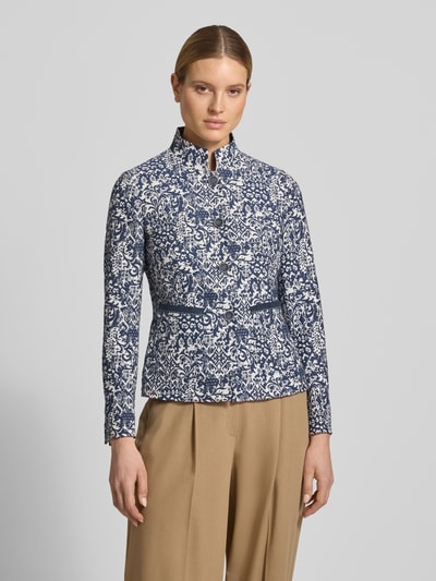 Modelka kobieca nosi Slim Fit Blazer im Allover-Look mit Stehkragen od WHITE LABEL z mieszanki materiałów z mieszanką bawełny, wzór na całej powierzchni w kolorach granatowym i białym, listwa guzikowa, długość tyłu w rozmiarze 36: 62 cm, szerokość w rozmiarze 36: 46 cm, długość rękawów w rozmiarze 36: 63 cm, całkowity widok z przodu.