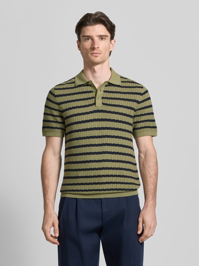 Männermodel trägt Poloshirt mit Polokragen und kurzer Knopfleiste von MCNEAL, gestreift in Grün und Dunkelblau, reine Baumwolle, Regular Fit, Ganzkörperansicht von vorne.