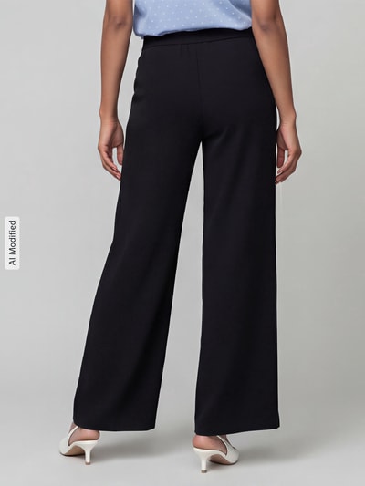 Frauenmodel trägt Weite Hose mit elastischem Bund Modell 'Coralie' von MAC in Schwarz, Damen Weite Hose von MAC, Ganzkörperansicht Rückansicht, KI-modifiziertes Bild.