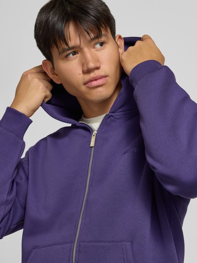 Männermodel trägt Relaxed Fit Sweatjacke aus Baumwoll-Mix mit Label-Detail von REVIEW, Violett, Kapuze, Känguru-Tasche, Nahaufnahme Oberkörper