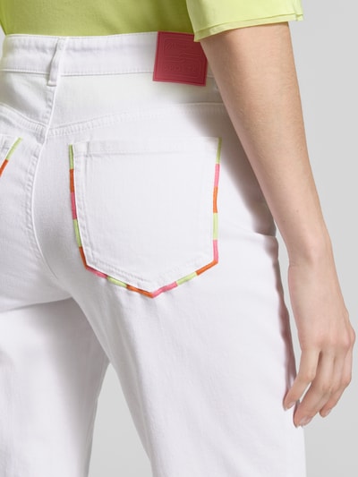 Frauenmodel trägt Relaxed Fit Jeans mit Stitchings von Marc Cain aus Baumwoll-Elasthan-Mix, weiße Farbe, Eingrifftaschen mit bunten Stitchings, Umschlag, Nahaufnahme Rückansicht.