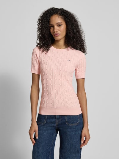 Frauenmodel trägt Strickshirt mit Zopfmuster und Label-Stitching von Gant in Rosa, Slim Fit, Baumwoll-Mix, Nahaufnahme Oberkörper.