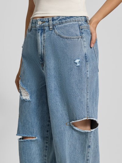 Kobieta nosi jeansy 'Jeans im Destroyed-Look mit Cut Outs' od Karo Kauer z bawełny, krój relaxed fit, przetarcia, wycięcia, wpuszczane kieszenie, szerokość w rozmiarze S: 37 cm, długość wewnętrzna nogawki w rozmiarze S: 71 cm, zbliżenie na górną część nóg.