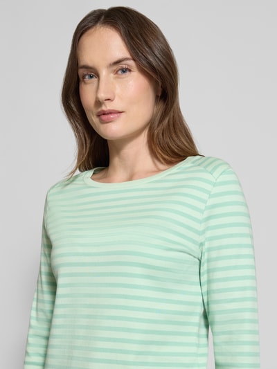 Frauenmodel trägt Regular Fit Langarmshirt aus reiner Bio-Baumwolle von Tom Tailor Denim, Allover-Muster, Rundhals, Interlock, Nahaufnahme Oberkörper.