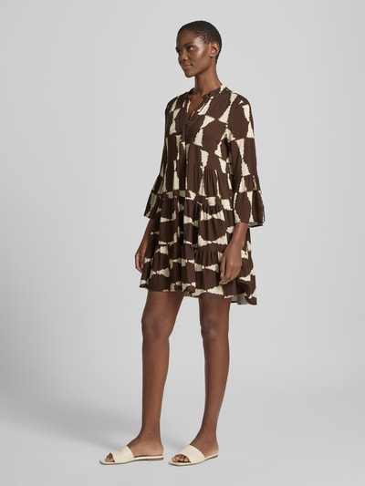 Frauenmodel trägt Minikleid aus Viskose mit 3/4-Arm Modell 'Me44lody' von ZABAIONE im Allover-Look, braun-beige, A-Linie, V-Ausschnitt, Ganzkörperansicht von vorne. Rückenlänge bei Größe S: 88 cm, Brustweite: 50 cm, Ärmellänge: 52 cm.