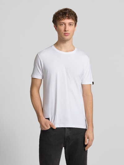 Männermodel trägt T-Shirt mit Label-Patch von Alpha Industries in Weiß, Reine Baumwolle, Gerader-Schnitt, Rundhalsausschnitt, Ganzkörperansicht von vorne
