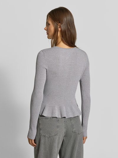 Frauenmodel trägt Strickjacke aus Viskose-Mix von MYON in Hellgrau, körpernahe Passform, Ripp-Optik, Bund mit Rüschen, Rückenansicht.