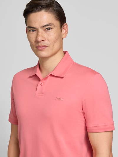Männermodel trägt Regular Fit Poloshirt aus reiner Baumwolle Modell 'PE_INTERLOCK' von BOSS Orange, Optik: Unifarben, Nahaufnahme Oberkörper.