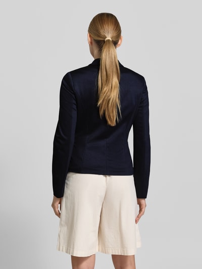 Frauenmodel trägt Slim Fit Blazer aus Viskose-Mix von Marc Cain in Dunkelblau mit Reverskragen, 2-Knopfverschluss, Pattentaschen, Rückenlänge 56 cm, Brustweite 23 cm, Ärmellänge 63 cm, Ganzkörperansicht Rückansicht.