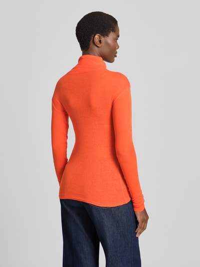 Frauenmodel trägt Slim Fit Rollkragenshirt aus reiner Baumwolle von American Vintage in Orange, fein gerippt mit Ziernähten, Ganzkörperansicht Rückansicht.