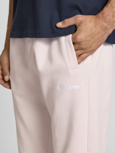 Männermodel trägt Straight Fit Sweatpants mit Logo-Stitching von Pegador aus Baumwoll-Mix mit Eingrifftaschen, Nahaufnahme Oberschenkel.