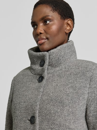 Frauenmodel trägt Regular Fit Mantel mit Baumwoll-Schrwoll-Anteil von FUCHS SCHMITT in Grau, Struktur sichtbar, Nahaufnahme Oberkörper. Material-Mix mit Stehkragen, Knöpfen und matter Textur.