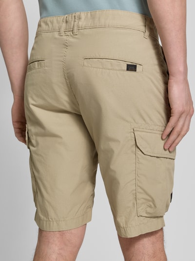 Männermodel trägt Bermudas mit Cargotaschen van camel active in beige, katoen, regular fit, cargozakken, detailopname achteraan.