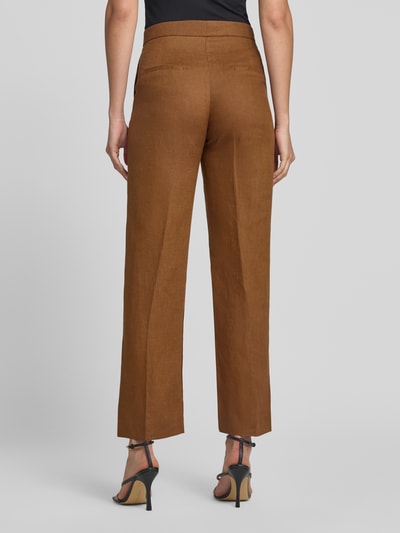 Frauenmodel trägt Straight Fit Leinenhose mit Bügelfalten Modell 'Boreli' von Mango in Braun, reine Leinen, Ganzkörperansicht Rückansicht.