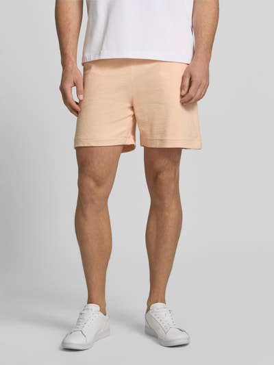 Männermodel trägt Regular Fit Sweatshorts aus reiner Baumwolle von Lacoste, Optik: Unifarben, Logo-Stitching, Crêpe, Ganzkörperansicht von vorne.