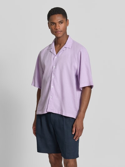 Męski model nosi Cropped Freizeithemd aus Leinen-Baumwoll-Mix od Lindbergh, mieszanka lnu i bawełny, krój krótki, kołnierz z połami, listwa guzikowa, długość tyłu w rozmiarze M: 70 cm, szerokość ramion w rozmiarze M: 49 cm, długość rękawów w rozmiarze M: 32 cm, jasnofioletowy, prosty krój, strukturalna tkanina, Ganzkörperansicht z przodu.