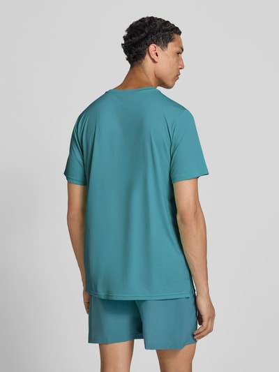 Męskimodel nosi Funktionsshirt mit Rundhalsausschnitt und Logo od New Balance, krój regular fit, okrągły dekolt, logo, długość tyłu w rozmiarze M: 69 cm, całkowity widok z tyłu.