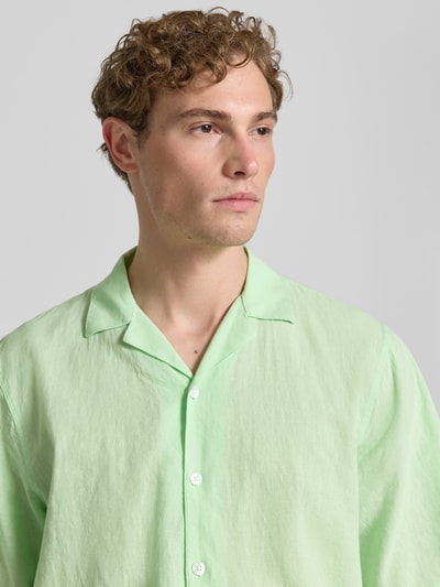 Männermodel trägt Cropped Freizeithemd aus Leinen-Baumwoll-Mix von Lindbergh in Hellgrün mit Reverskragen und Knopfleiste, Nahaufnahme Oberkörper.