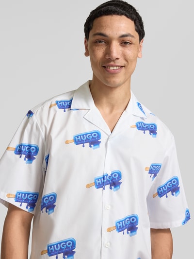 Männermodel trägt Relaxed Fit Freizeithemd aus reiner Baumwolle Modell 'ELIGINO' von Hugo Blue, Optik: Allover-Muster, Kurzarm, Nahaufnahme Oberkörper.