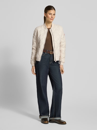 Frauenmodel trägt Steppjacke mit Zweiwege-Reißverschluss Modell 'BOY' von Frieda & Freddies in Beige, gesteppt, Regular Fit, Ganzkörperansicht von vorne.