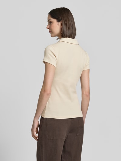 Frauenmodel trägt Damen T-Shirt mit Polokragen Modell 'Kleoh Polo' von Someday, Baumwoll-Elasthan-Mix, Ripp-Optik, Slim-Fit, Rückenlänge 60 cm, Ganzkörperansicht Rückansicht.
